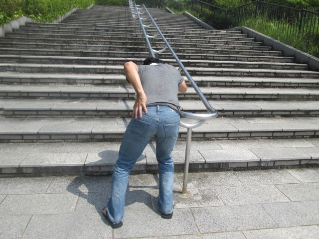 腰を抑える男性の写真